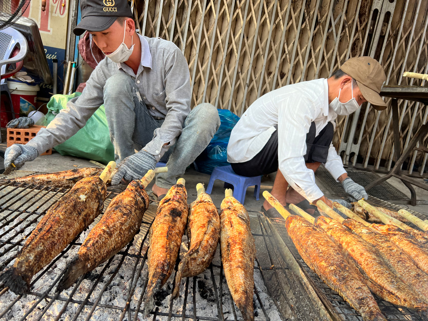 Nhân viên bày bếp than ngay trên vỉa hè nướng cá Nhân viên bày bếp than ngay trên vỉa hè nướng cá