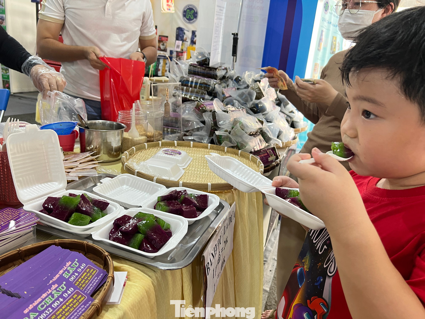 Một khách hàng nhí thích thú thưởng thức ngay tại chỗ món bánh đúc lá dứa mềm mềm, thơm thơm ăn kèm với nước cốt dừa. Mỗi hộp có giá 20.000 đồng.