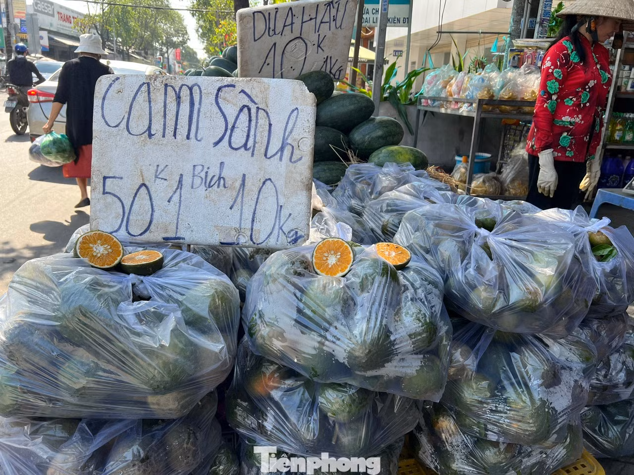 Trưa ngày 7/11, trên đường Phạm Hùng (huyện Bình Chánh, TPHCM), tiểu thương bày hàng chục bịch cam sành ngay trên vỉa hè, mở loa oang oang chào mời khách mua cam với giá 50.000 đồng/bịch 10kg. "Cam sành ở miền Tây đang vào mùa nên già trái, ngọt nước, em mua về uống tăng cường vitamin C giúp giải nhiệt nắng nóng, rất tốt cho sức khỏe" - người bán mời khách.
