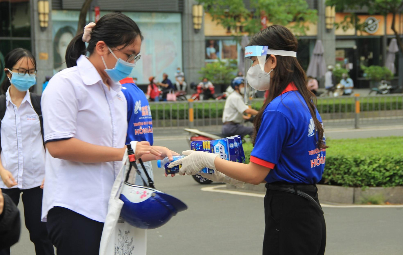 Thí sinh tại điểm thi trường THPT Hùng Vương được các tình nguyện viên "Tiếp sức mùa thi" chăm sóc trước giờ vào thi.