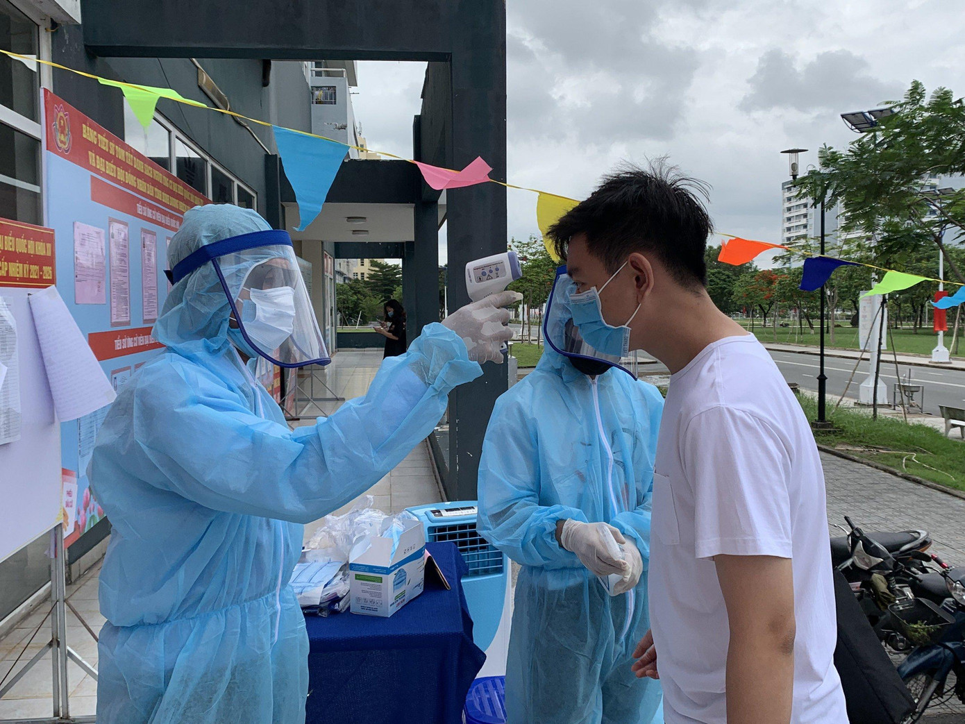 Kiểm tra thân nhiệt của cử tri trước khi vào khu vực bỏ phiếu.