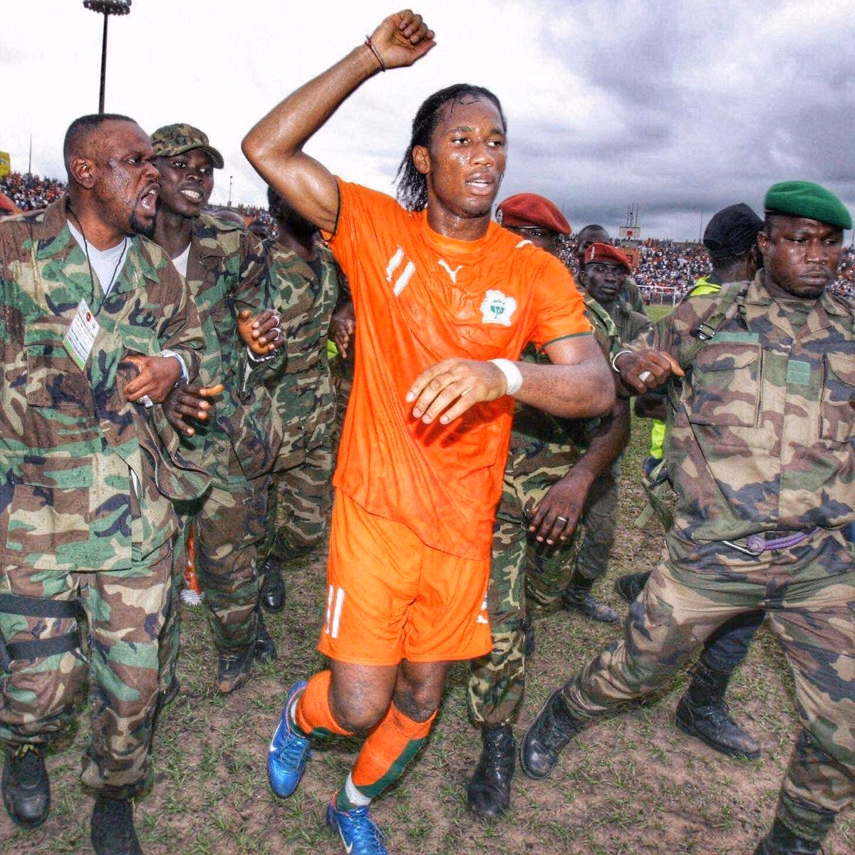Didier Drogba trong vòng vây của cảnh sát sau trận đấu lịch sử với Sudan năm 2005.