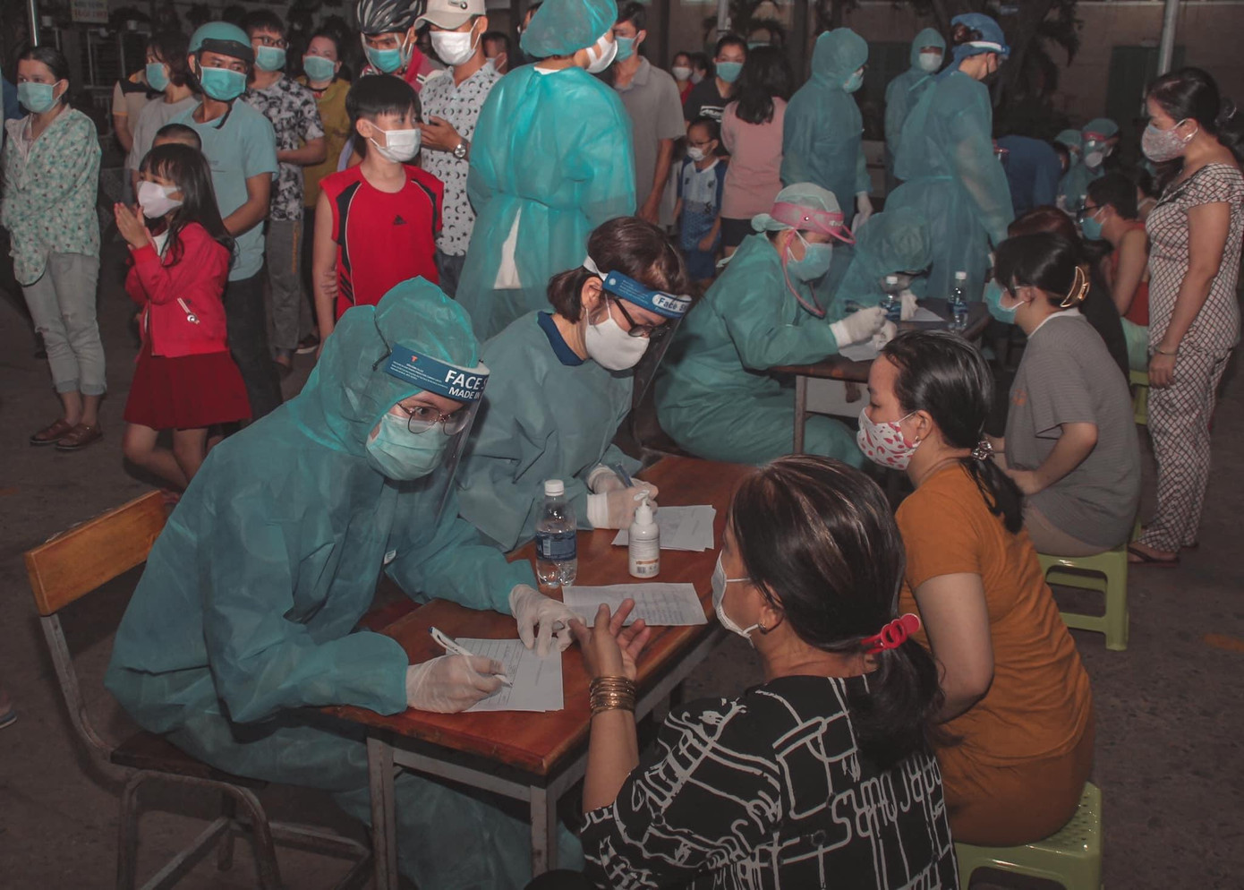 Ngọc Ánh (bên phải) đang ghi thông tin giúp người dân tại điểm lấy mẫu xét nghiệm ở Quận 12.