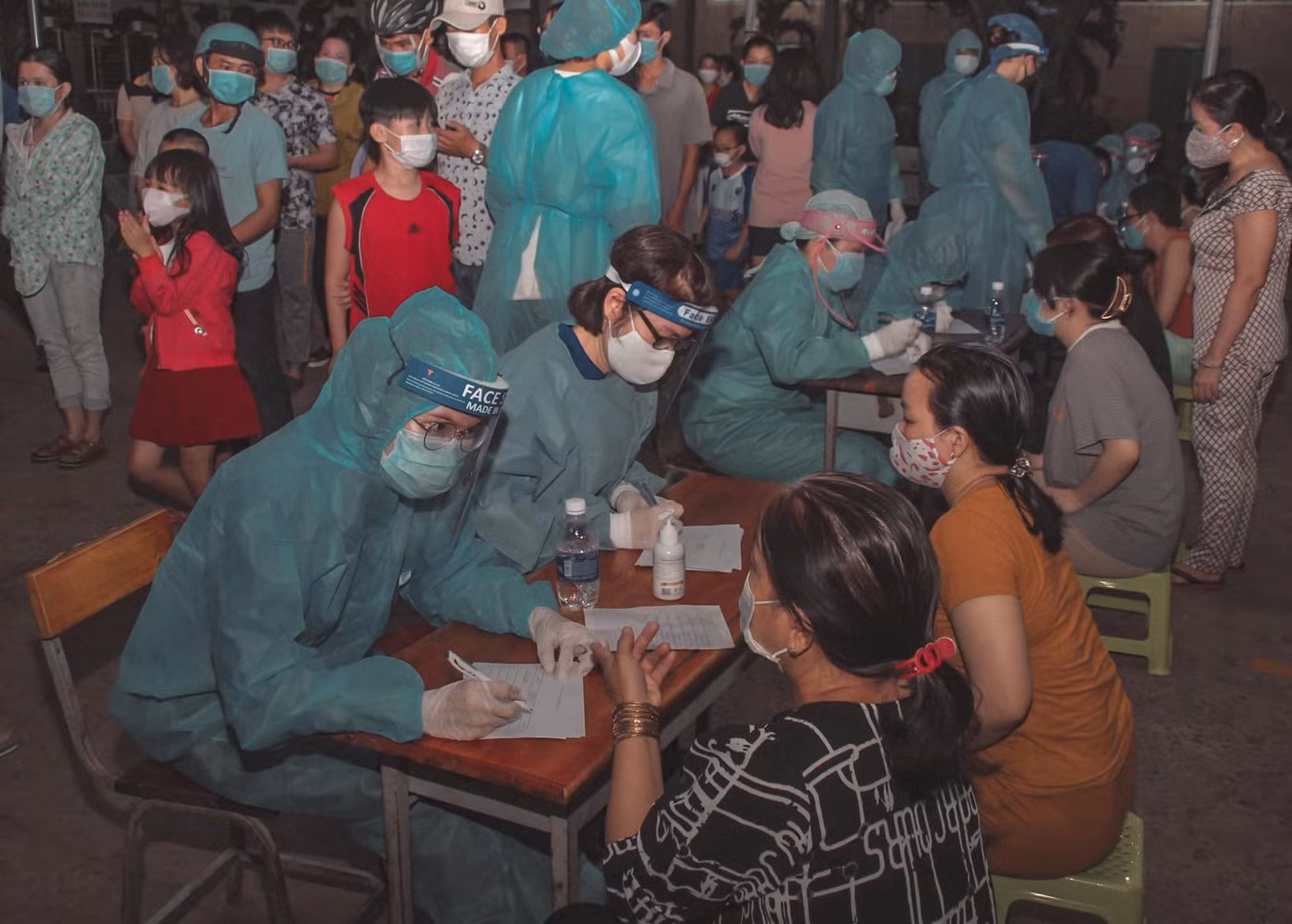 Ngọc Ánh (bên phải) đang ghi thông tin giúp người dân tại điểm lấy mẫu xét nghiệm ở Quận 12.