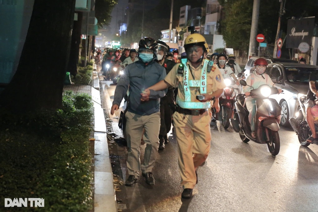 CSGT cầm tay dẫn ông V.T.T. về chốt (Ảnh: An Huy).