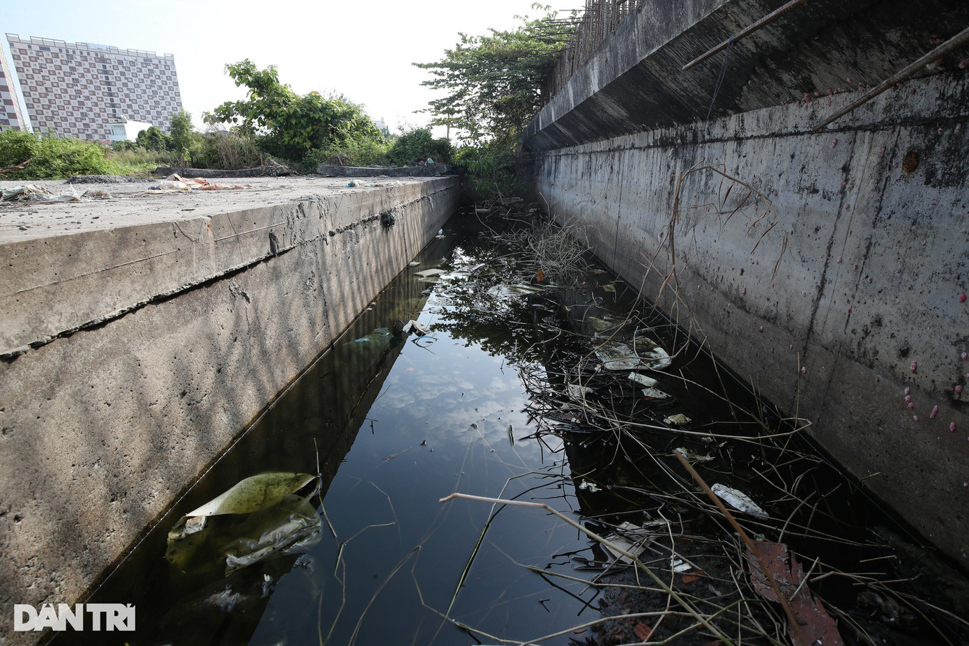 Một hố đào tại công trình bị đọng nước, đầy rác.
