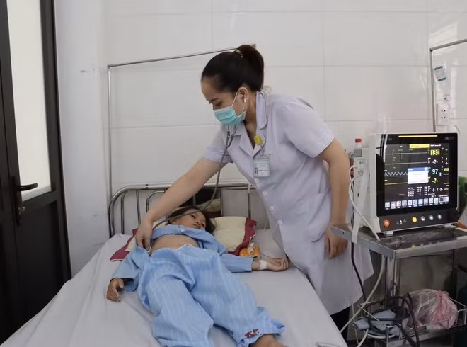 Bác sĩ tại Trung tâm y tế huyện Nghi Xuân thăm khám chữa cho bệnh nhi. Ảnh: Hoàng Ngà - TTXVN