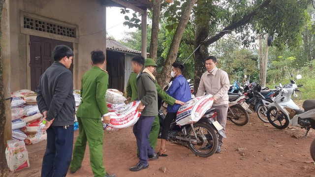 Lực lượng chức năng tiếp nhận các bao gạo, nếp người dân giao nộp vào sáng 14-1