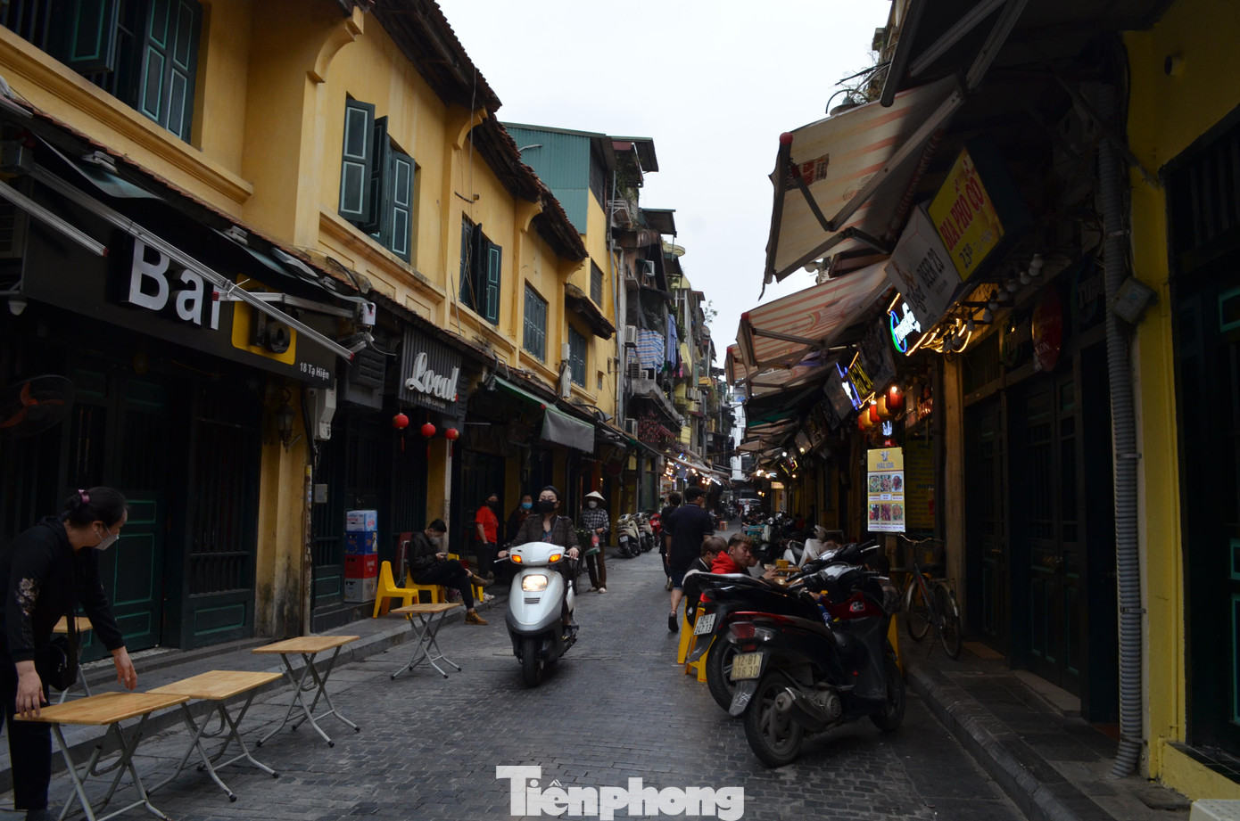 Các chủ cửa hàng trên phố Tạ Hiện vẫn kiên trì chuẩn bị bàn ghế đón khách vào buổi tối.