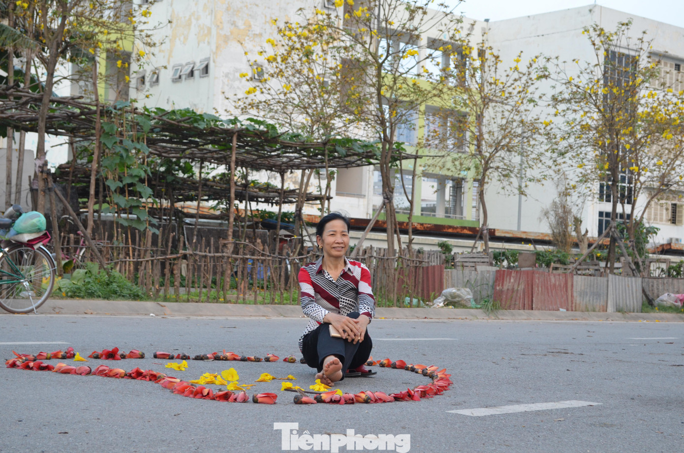 "Tôi đi làm qua đây thấy hoa đẹp quá nên đỗ lại tự chụp cho mình vài kiểu. Suốt ngày tối mặt, tối mũi, nay rảnh cũng phải vui thú một chút cho đời thêm tươi", cô Nguyễn Thị Thành - người làm công việc nhặt phế liệu nhiều năm qua chia sẻ.