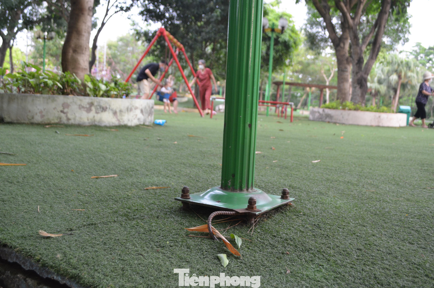 Một vị trí chân cột đèn chiếu sáng nhô hẳn lên bề mặt thảm cỏ. Những ốc vít cao hàng centimet như cái bẫy đối với người dân, nhất là trẻ em.