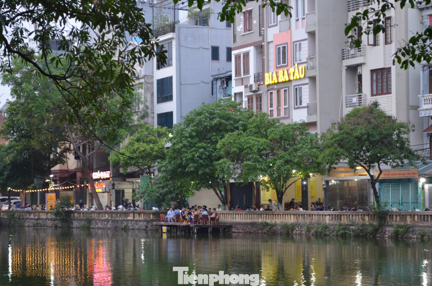 Trong ảnh là hồ Trung Kính (phường Trung Hòa, quận Cầu Giấy). Hồ này không có đường bờ kè nhưng quán bia "Ba Tàu" kê bàn cho khách ngồi nhậu ở một bệ bê tông dựng ngay trên mặt nước.