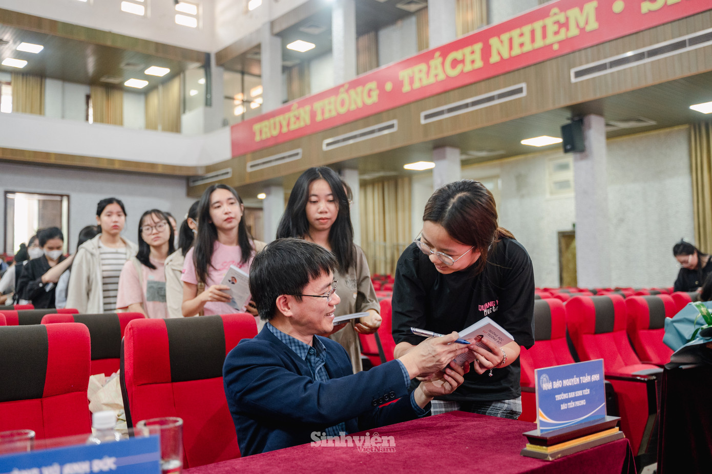 Tác giả, nhà báo Nguyễn Tuấn Anh ký tặng cuốn sách "Trường học hay Trường đời" cho sinh viên Trường Đại học Thương mại.