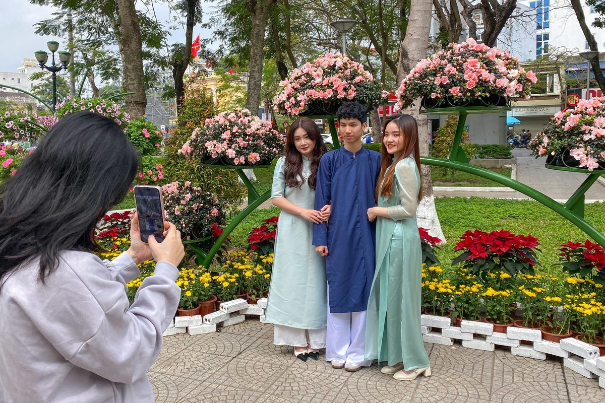 Nhóm bạn Hồng Anh, Thuỳ Dương và Tùng Dương đang nhờ người đi đường chụp hộ.