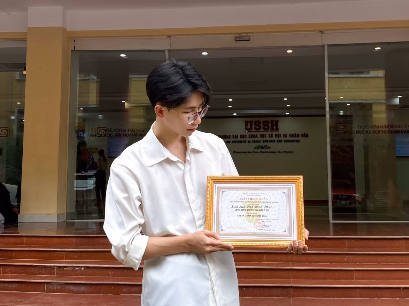 Phúc nhận giấy khen khen thưởng của nhà trường.