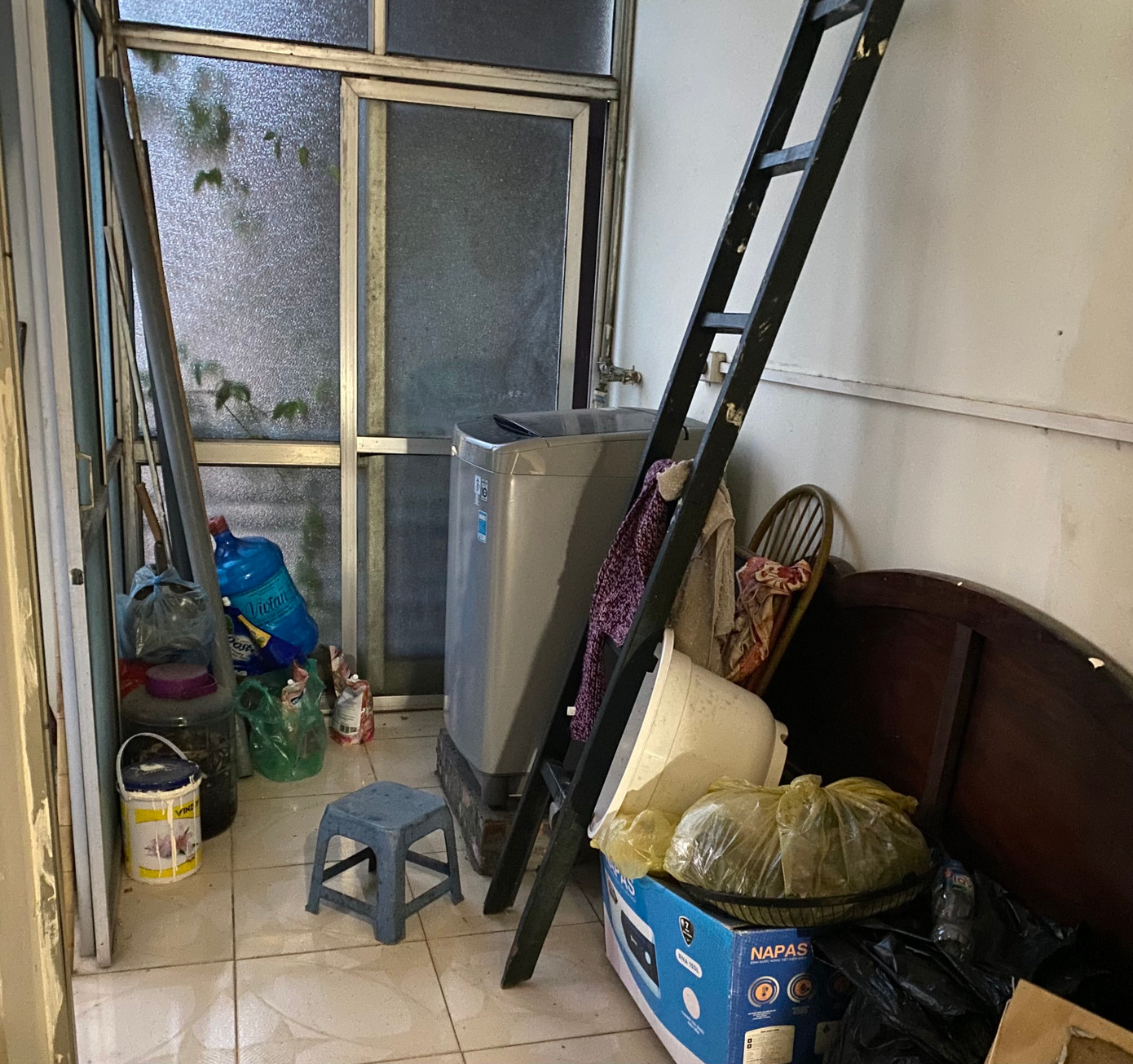 Đồ đạc lộn xộn, xếp chồng lên nhau trong căn phòng của C.