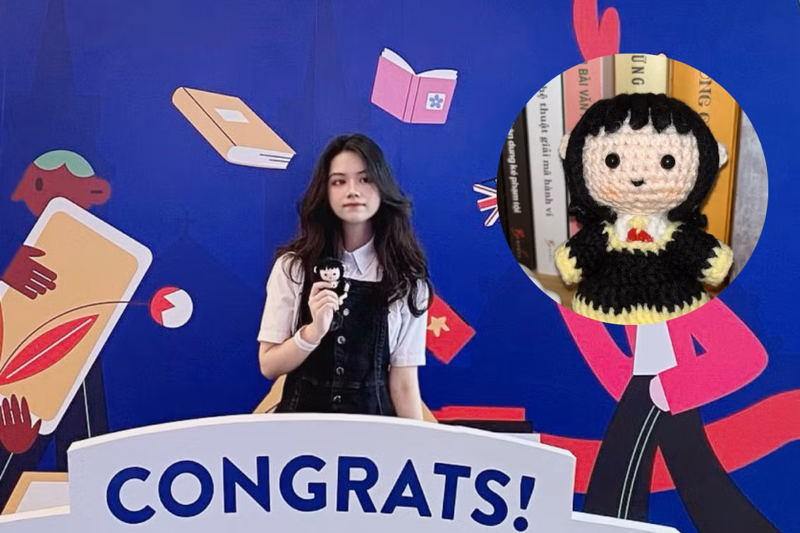 Khanh mang theo búp bê may mắn cùng đến nhận học bổng.