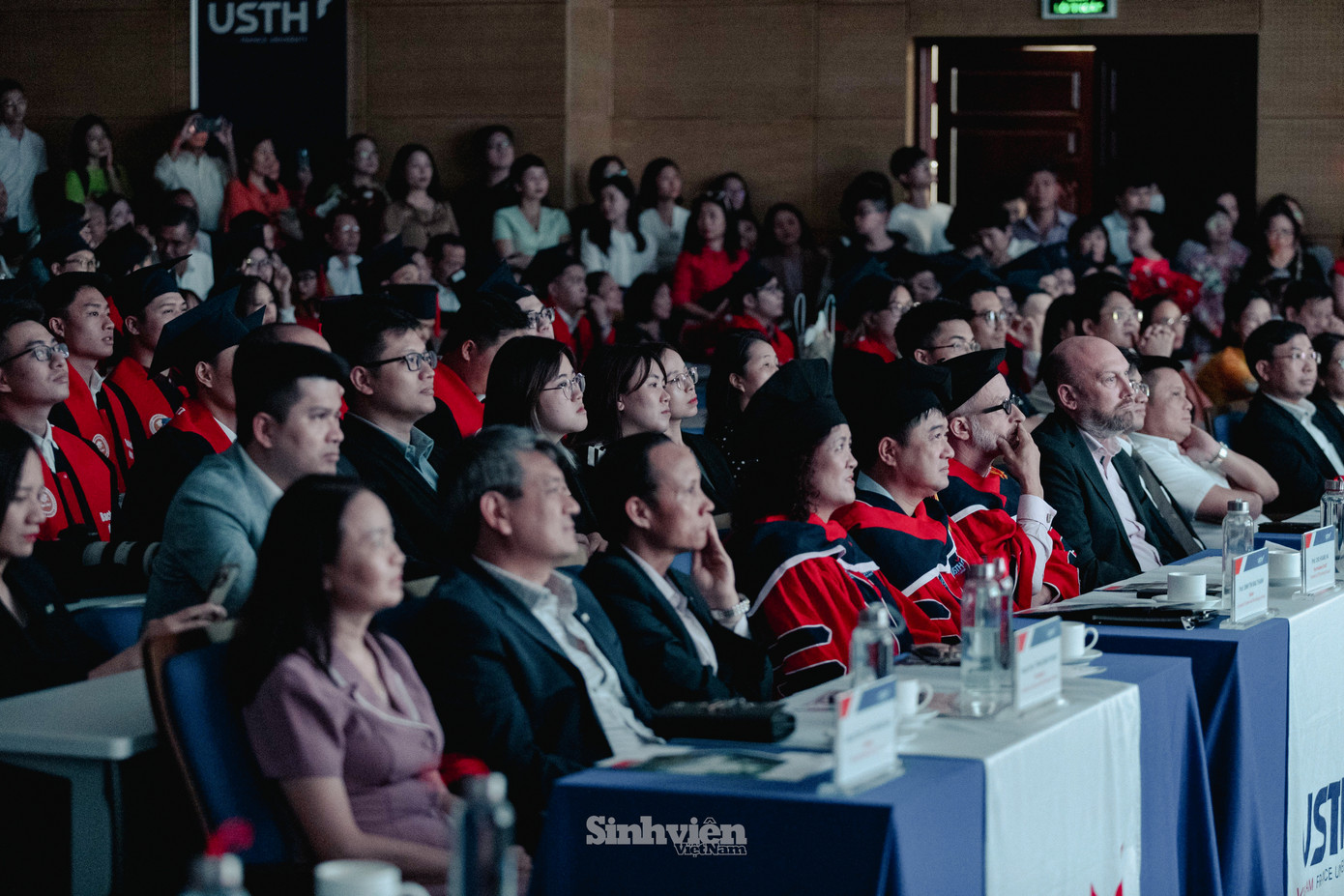 Các tân cử nhân, thạc sĩ, tiến sĩ cùng xem thước phim về hành trình không ngừng nỗ lực học tập, nghiên cứu và phát triển tại USTH.