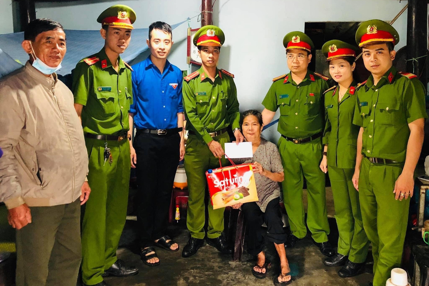 Cùng với công an xã Tam Dân, anh Bảo (mặc áo xanh thanh niên) tặng quà cho người già neo đơn có hoàn cảnh khó khăn.