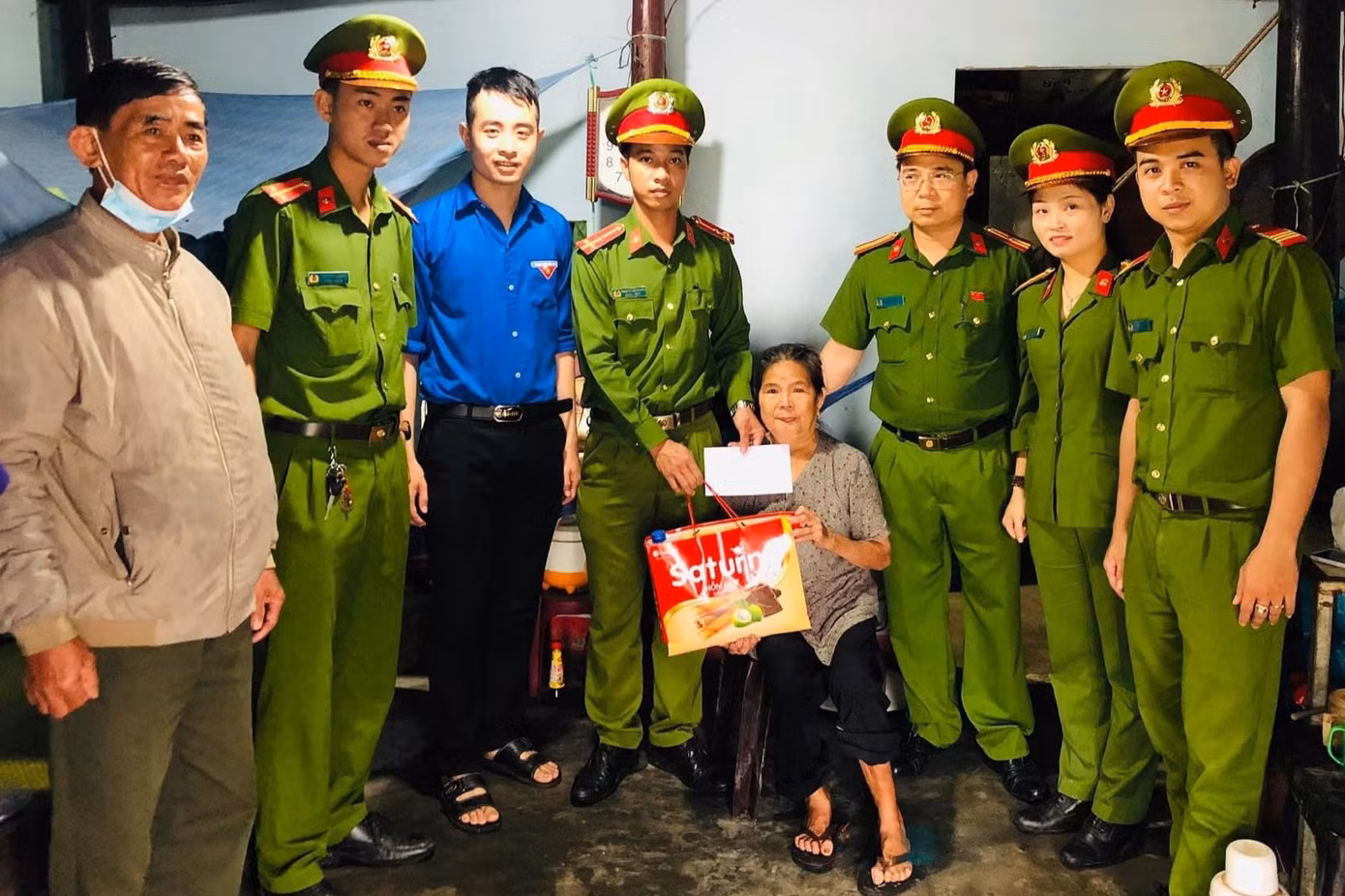 Cùng với công an xã Tam Dân, anh Bảo (mặc áo xanh thanh niên) tặng quà cho người già neo đơn có hoàn cảnh khó khăn.