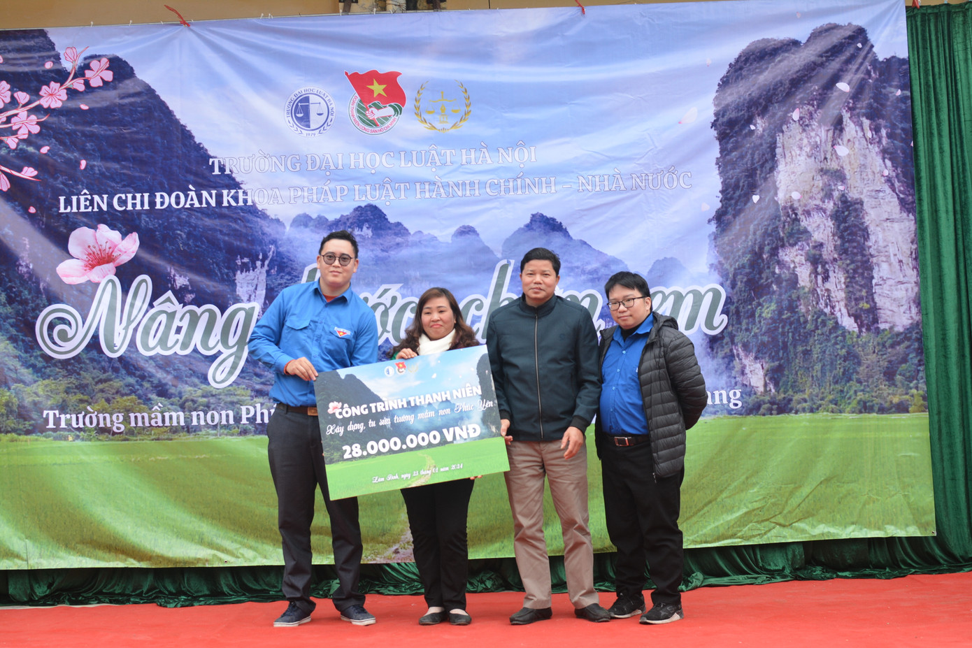 Thầy Đậu Công Hiệp - Phó Bí thư Liên chi Đoàn Trường Đại học Luật Hà Nội trao quà đến đại diện lãnh đạo nhà trường và lãnh đạo xã Phúc Yên.