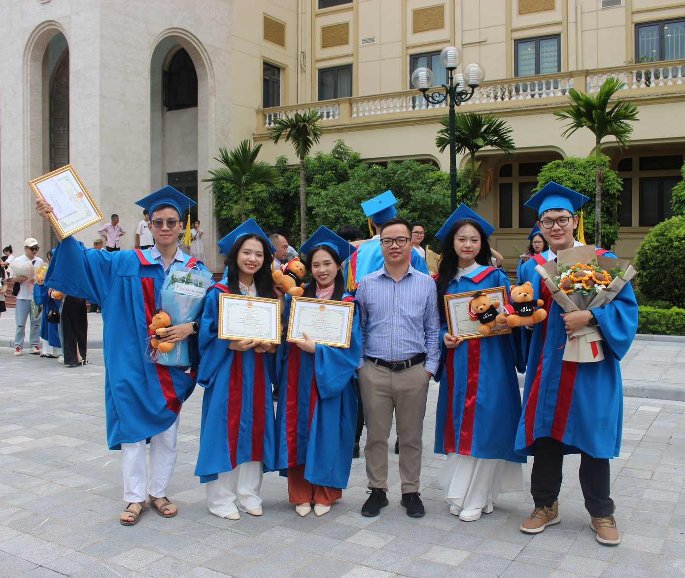 Hồng Ngọc chụp ảnh kỉ niệm cùng thầy và các bạn trong ngày tốt nghiệp.