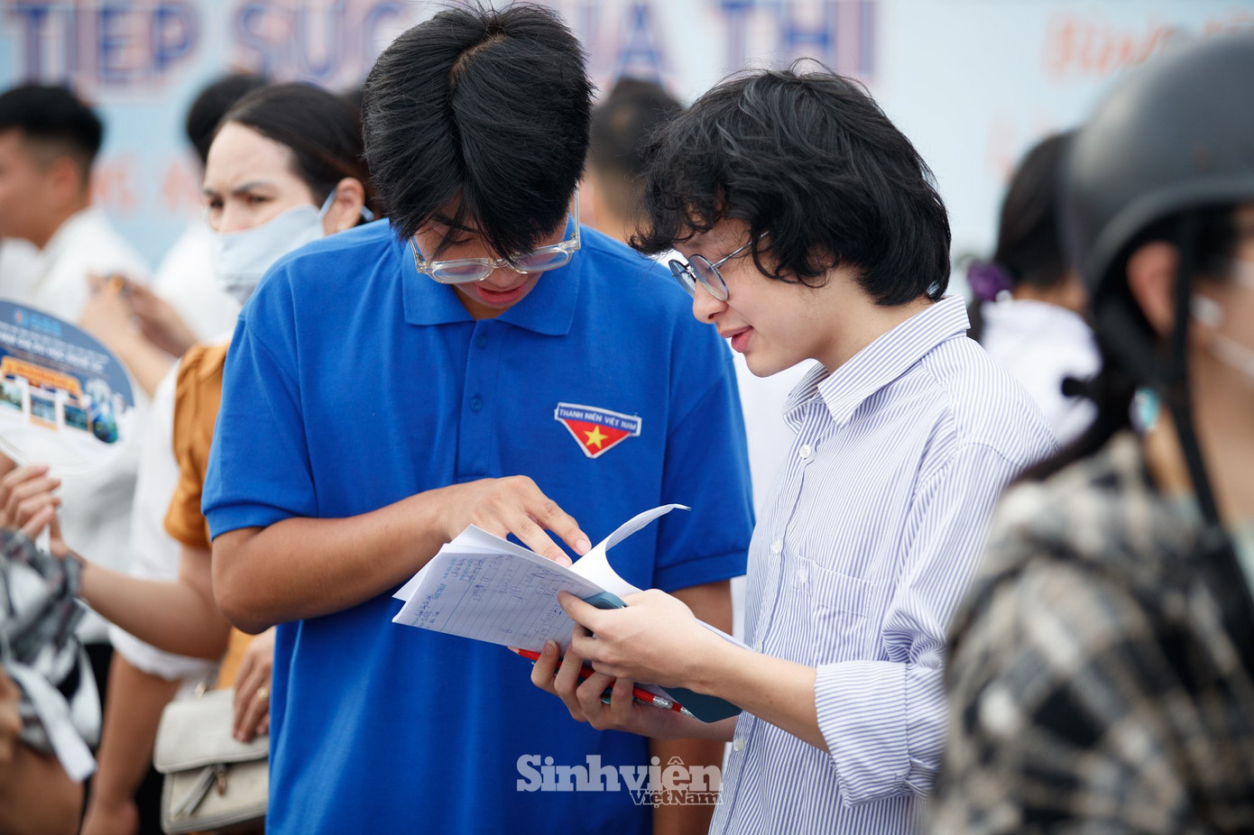 Thí sinh trao đổi bài với tình nguyện viên tại điểm thi Trường THPT Chuyên Thái Nguyên.