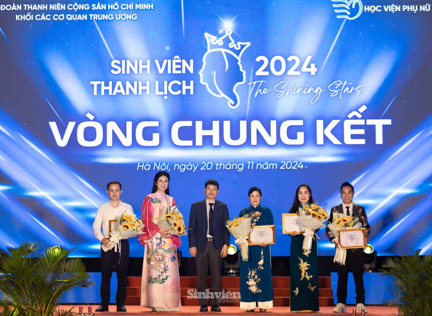 PGS. TS Trần Quang Tiến - Giám đốc Học viện Phụ nữ Việt Nam tặng hoa, giấy chứng nhận, cảm ơn Ban Giám khảo đêm Chung kết Sinh viên Thanh lịch 2024: anh Đỗ Công Tuân - Uỷ viên BCH Trung ương Đoàn, Phó Trưởng Ban Tuyên giáo Trung ương Đoàn; Hoa hậu Ngọc Hân; bà Hà Thị Thanh Vân - PGĐ Học viện Phụ nữ Việt Nam; NSND Trịnh Thuý Mùi - Chủ tịch Hội Nghệ sĩ Sân khấu Việt Nam và nhà báo Ngô Bá Lục.