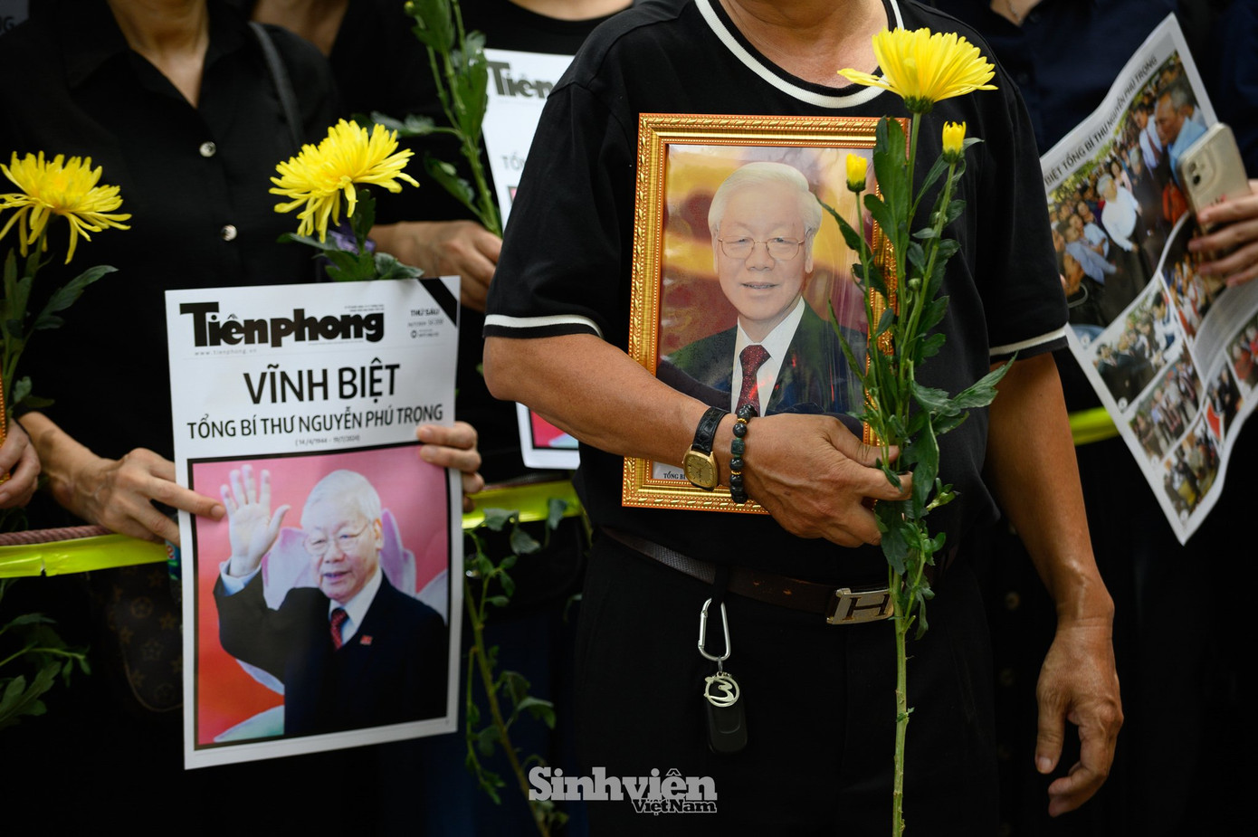 Người dân mang theo hoa cúc, di ảnh của Tổng Bí thư.
