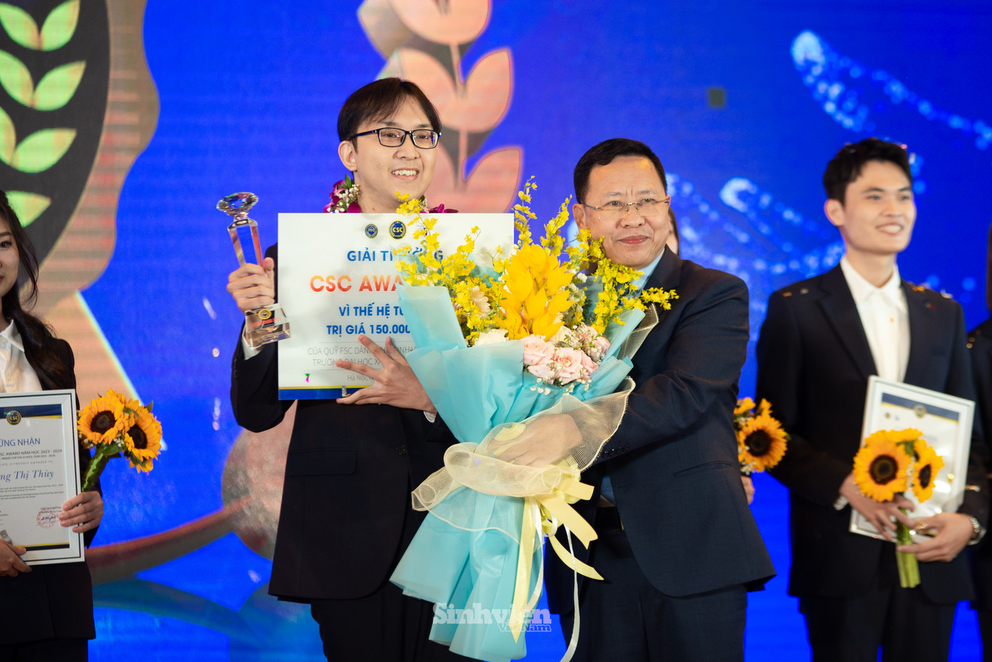 Ông Trần Văn Đạt - Vụ trưởng Vụ Giáo dục Chính trị và Công tác HSSV - Bộ GD&ĐT tặng hoa chúc mừng sinh viên Nguyễn Tấn Phong. Ông Trần Văn Đạt - Vụ trưởng Vụ Giáo dục Chính trị và Công tác HSSV - Bộ GD&ĐT tặng hoa chúc mừng sinh viên Nguyễn Tấn Phong.