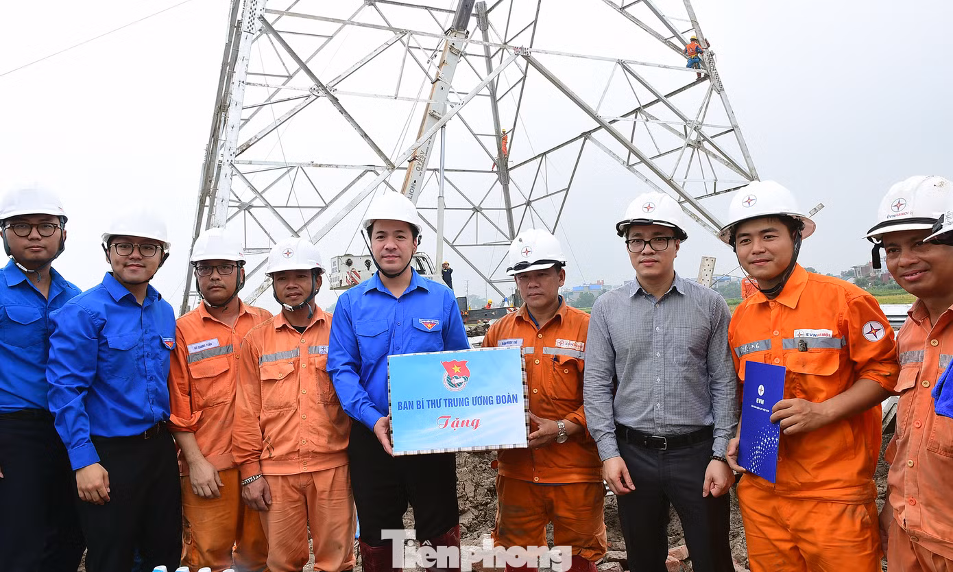 Anh Ngô Văn Cương tặng quà thanh niên công nhân thi công đường dây tại xã Hòa Phong (thị xã Mỹ Hào, Hưng Yên). Ảnh: Xuân Tùng