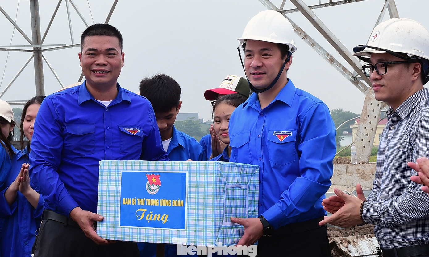 Anh Ngô Văn Cương tặng quà đội TNTN hỗ trợ thi công đường dây tại xã Hoà Phong (thị xã Mỹ Hào, Hưng Yên). Ảnh: Xuân Tùng