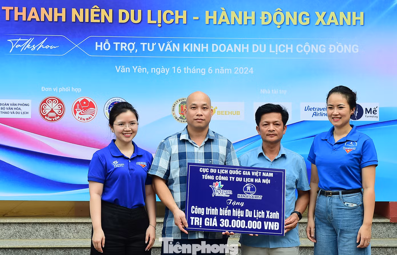 Đại diện Ban Tổ chức trao tặng công trình thanh niên biển hiệu Du lịch Xanh tại ruộng bậc thang Khe Táu được trao tặng tại chương trình. Ảnh: Xuân Tùng