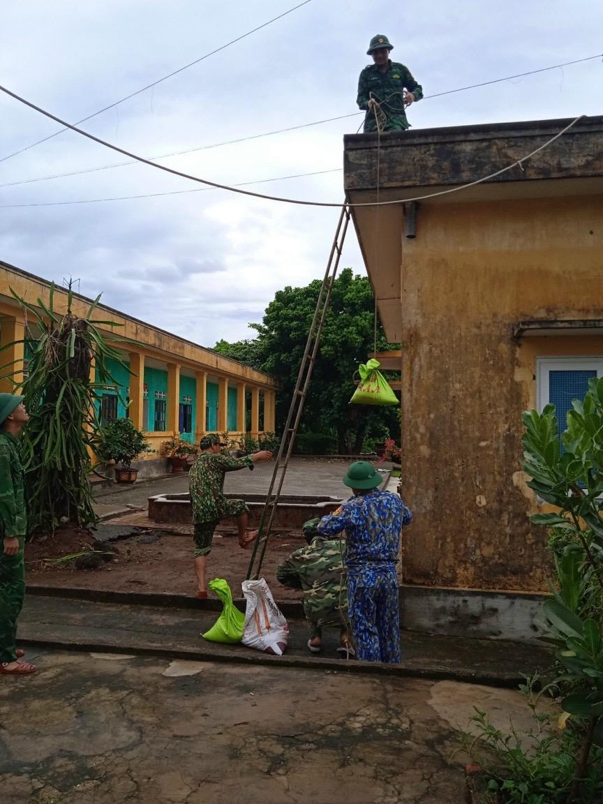 Quân dân huyện đảo Cồn Cỏ đổ cát vào bao để gia cố các công trình phòng tránh bão Noru. Ảnh: CC.