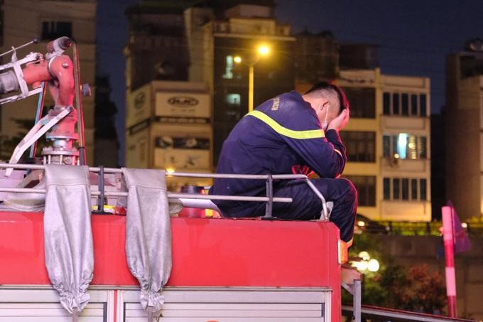 Một chiến sĩ PCCC ôm mặt khóc trên nóc xe cứu hỏa trước khi trở về đơn vị