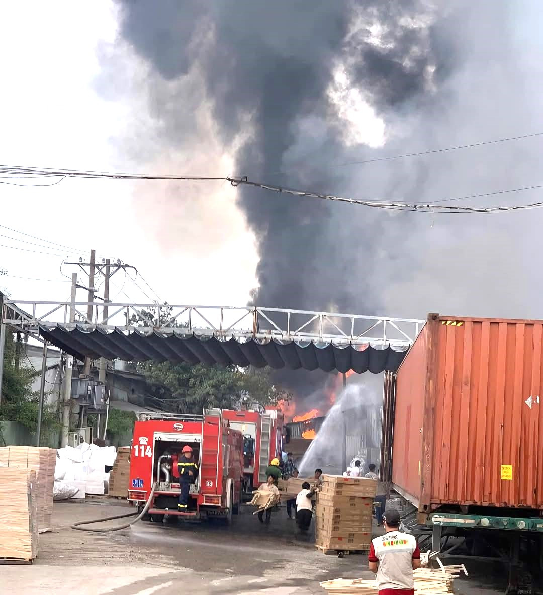 Lực lượng chức năng và công nhân nỗ lực khống chế ngọn lửa, di chuyển tài sản ra khỏi đám cháy.