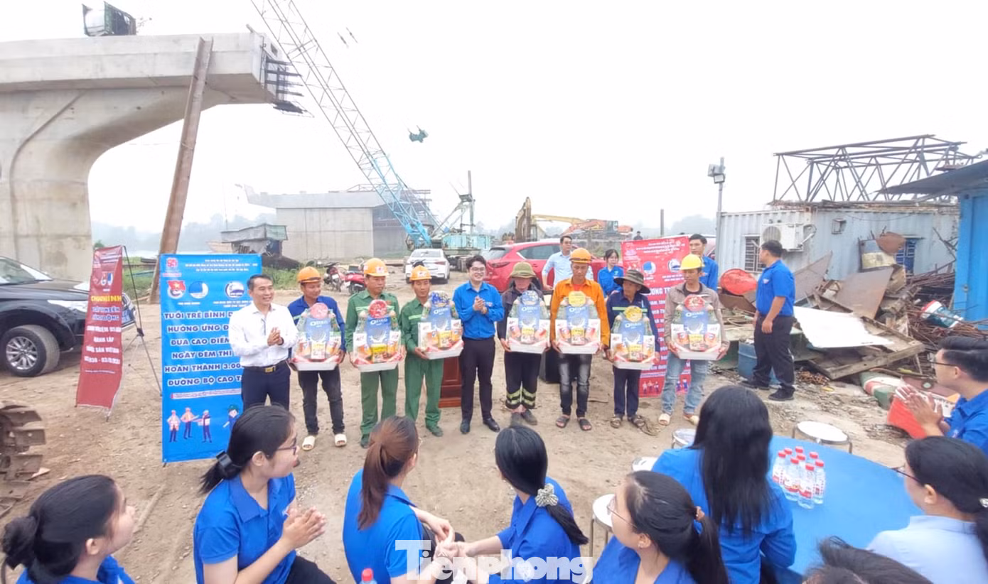 Ông Võ Ngọc Sang - Phó Giám đốc Ban Quản lý dự án đầu tư xây dựng công trình giao thông tỉnh Bình Dương và anh Nguyễn Minh Sơn - Phó Bí thư Tỉnh Đoàn Bình Dương tặng quà thanh niên công nhân làm việc tại công trình đường Vành đai 3 TPHCM.