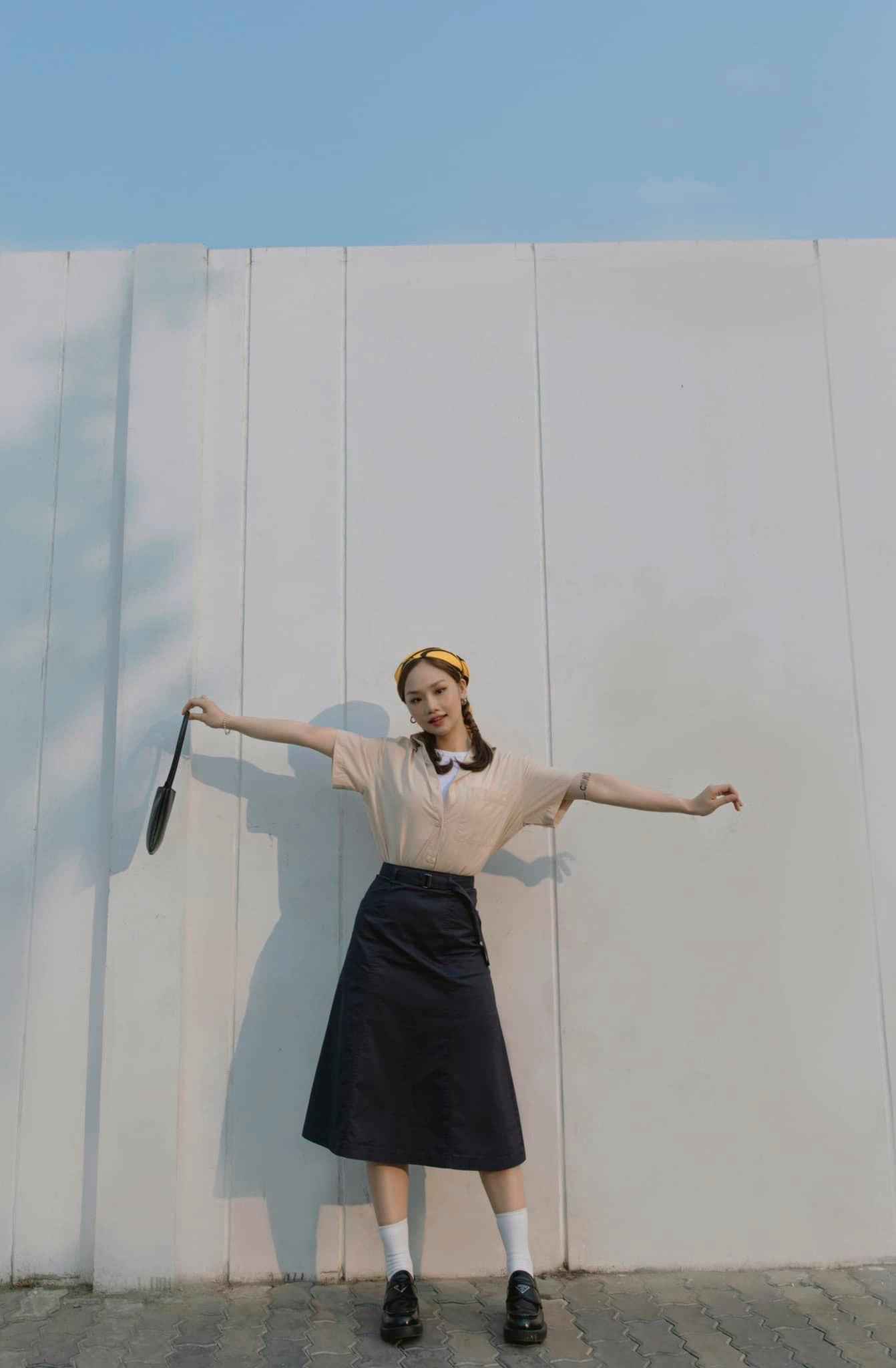 Chân váy đen dài phối cùng khăn quấn đầu vàng rực kết hợp với kiểu tóc thắt bím, Miu Lê biến hình thành cô nàng trẻ trung, thời thượng.