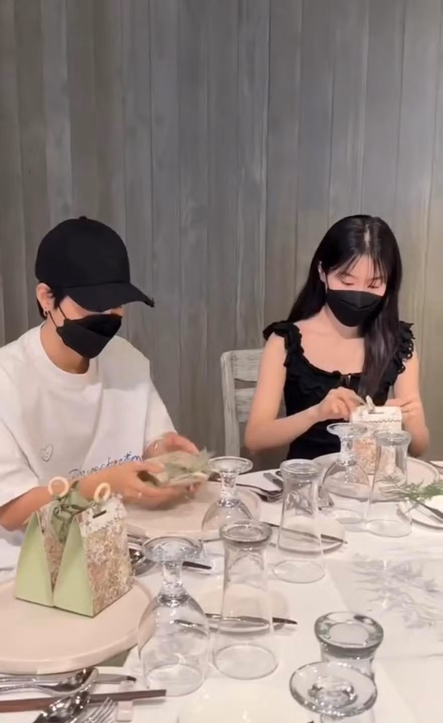 Vũ Cát Tường - Thu Trang đeo khẩu trang đen, ngồi ở bàn tiệc cẩn thận gói quà cho khách mời tham dự lễ thành đôi diễn ra vào ngày 12/2.