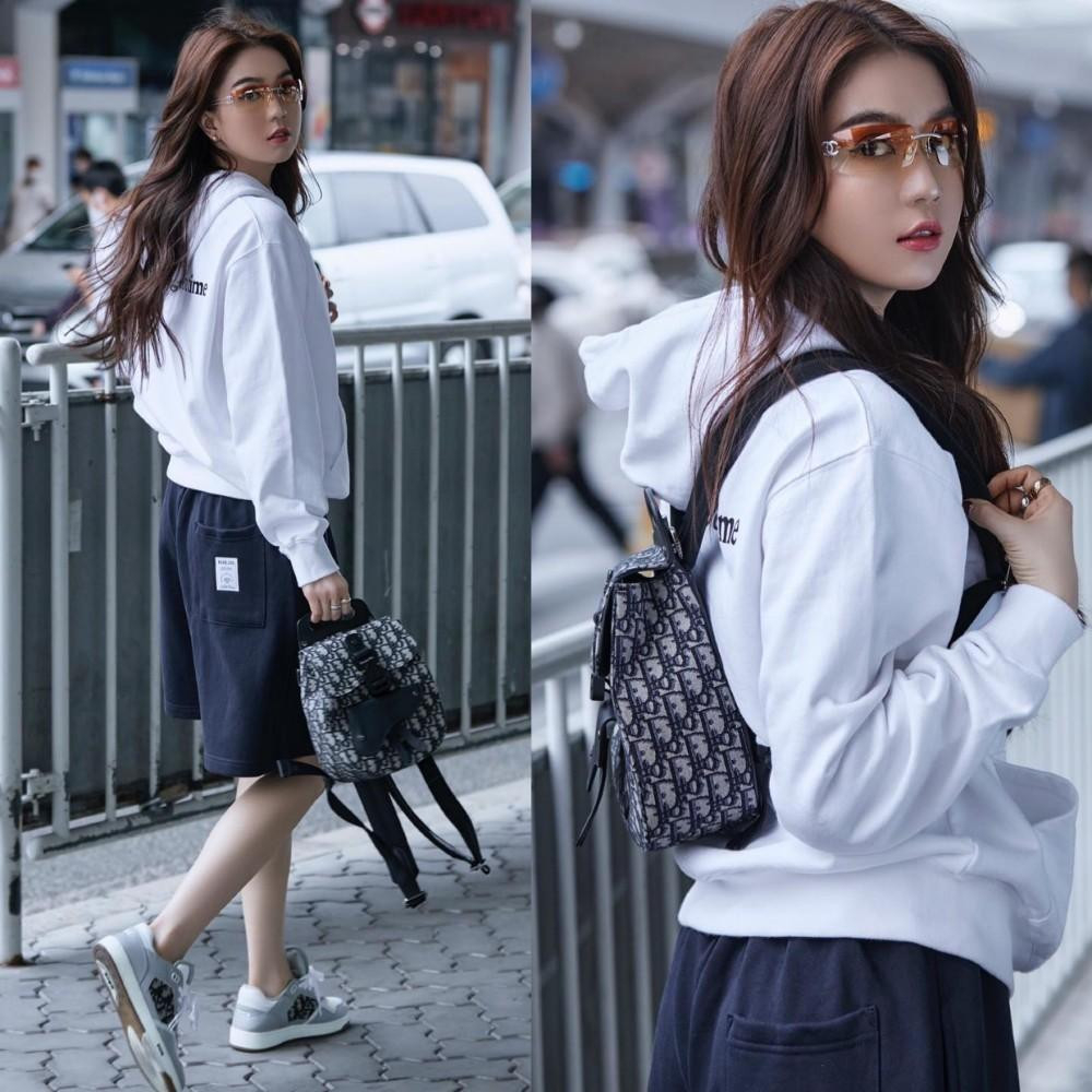 Ngọc Trinh chọn áo hoodie trắng kết hợp cùng balo và giày thể thao cho chuyến bay dài.