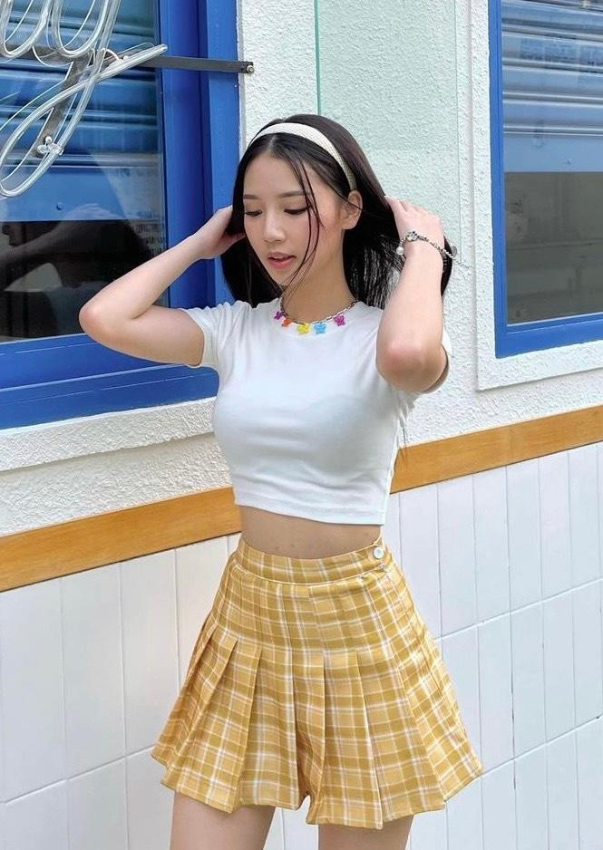 Chỉ với chân váy sọc ca rô vàng và băng đô, AMEE giúp outfit không bị nhạt nhòa và khoe được vóc dáng thon gọn của bản thân.