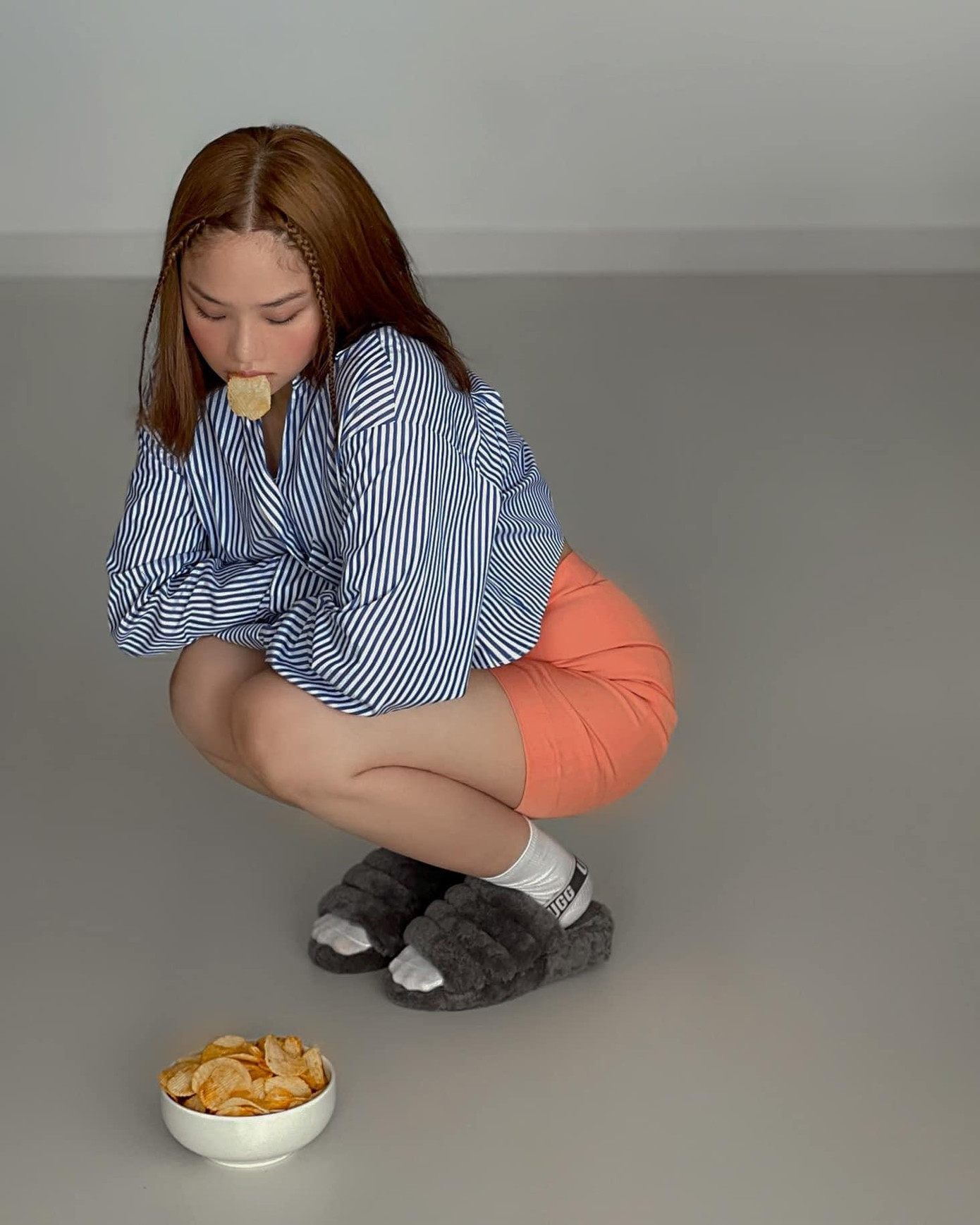 Nữ ca sĩ phối áo sơ mi họa tiết vertical stripes với quần tập sáng màu.