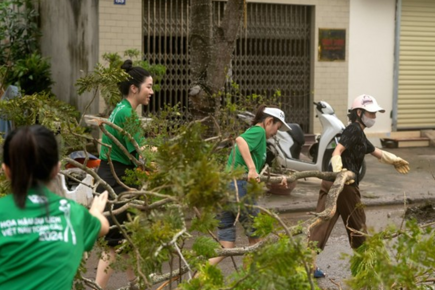 Các thí sinh Hoa hậu Du lịch Toàn cầu Việt Nam 2024 hỗ trợ người dân dọn cây sau cơn bão tại Hải Phòng.