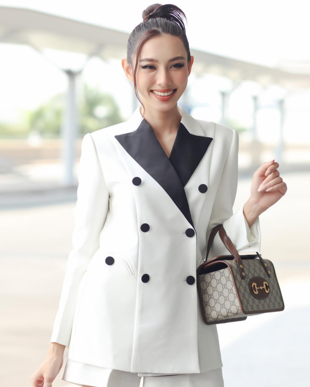 Suit trắng kết hợp với túi hiệu có họa tiết đơn giản giúp Thùy Tiên trông trẻ trung, năng động.