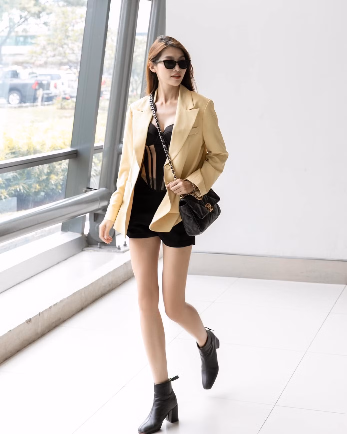 Người đẹp chọn blazer mặc cùng áo ôm sát, giày boots cổ thấp và mắt kính đen.