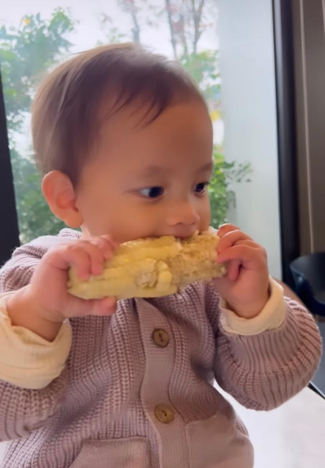 Lisa đang tận hưởng món bắp luộc khoái khẩu của cô bé.