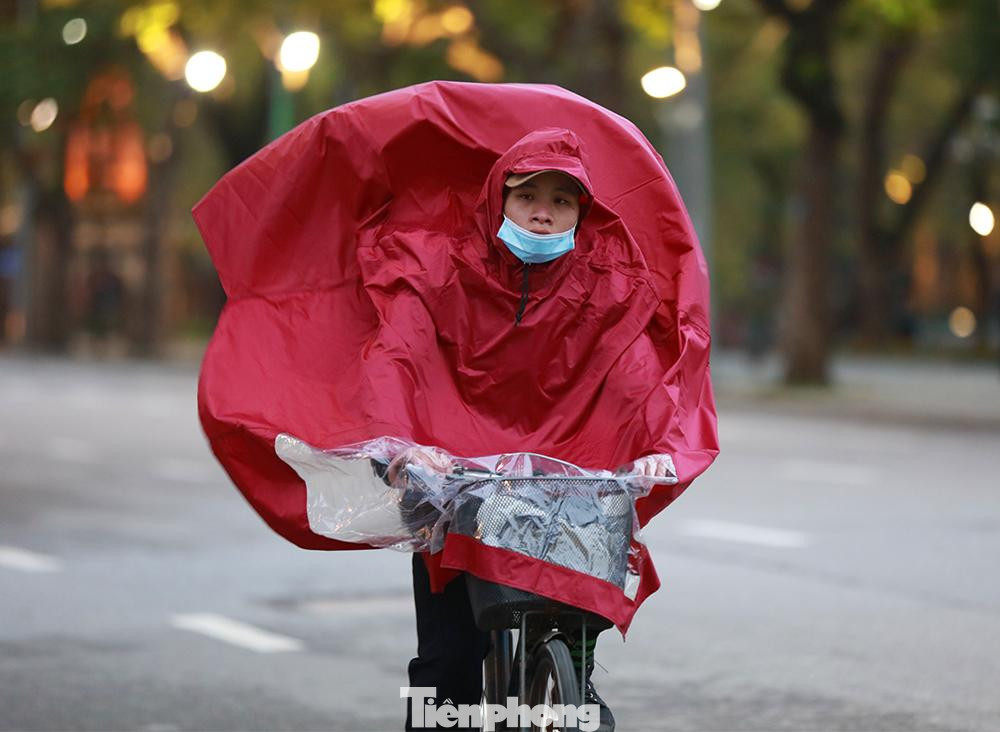 Dù không mưa nhưng người dân vẫn mặc thêm áo mưa đạp xe tập thể dục bất chấp giá rét.