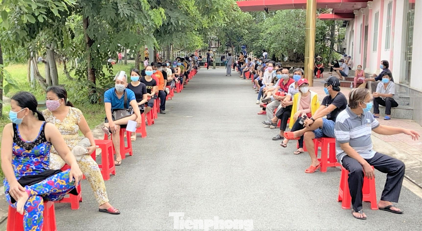 Rất đông người dân ngồi chờ để đến lượt tiêm