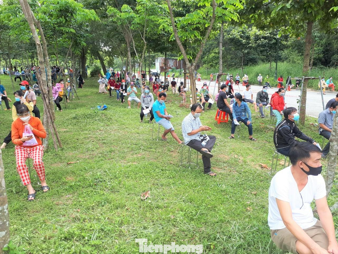 Hàng trăm người dân xếp hàng dưới vườn cây xanh chờ tiêm vắc xin. “Thật sự, tôi không nghĩ gười dân đến điểm tiêm đông như vậy. Chúng tôi liên tục chạy đến điểm bảo quản vắc xin để lấy tiếp số lượng. Do ngày đầu triển khai nên chúng tôi lấy lượng vắc xin vừa phải. Tuy nhiên, người dân đến số lượng lớn buộc phải đáp ứng”, đại diện Ban chỉ đạo phòng, chống dịch TP Dĩ An, Bình Dương, nói.