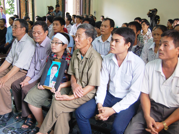 Người nhà bị hại mang di ảnh đến dự tòa